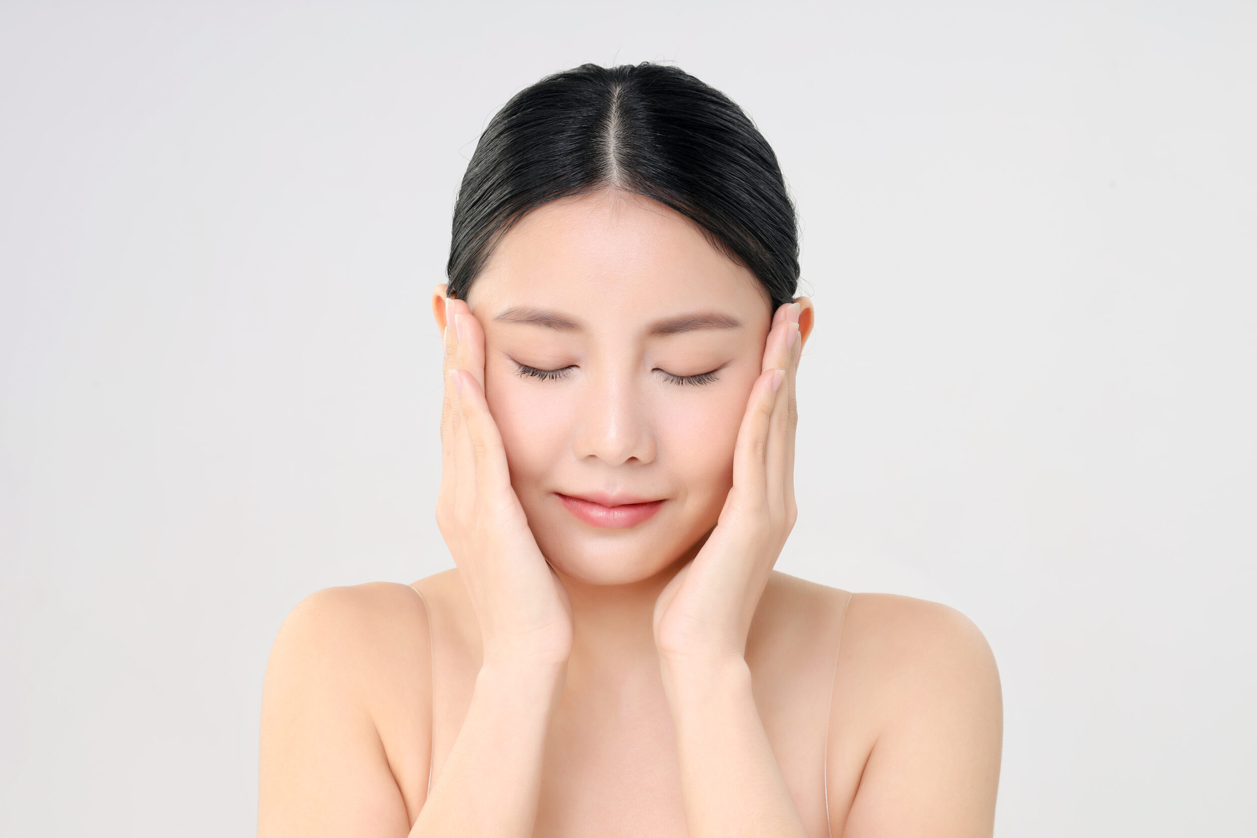 beautiful face young adult asian woman with clean fresh skin isolated white